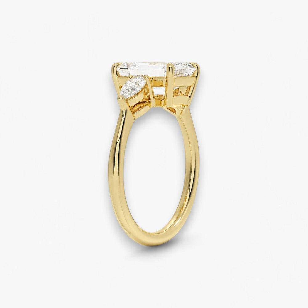 Eleganter Verlobungsring mit 2-Karat Emerald-Cut-Diamant und funkelnden seitlichen Pear-Cut-Diamanten, gefertigt aus hochwertigem Gelbgold. Luxuriöser Diamantring für Verlobung, Hochzeit oder Jubiläum. Exklusives Schmuckdesign mit brillantem Glanz und zeitloser Eleganz – ideal für besondere Momente. Perfekter Verlobungsring mit außergewöhnlicher Handwerkskunst. Jetzt online entdecken und bestellen.