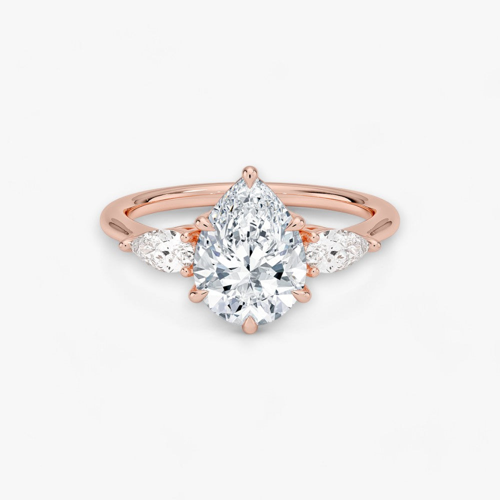 Eleganter Verlobungsring mit 2-Karat Tropfen-Cut-Diamant und funkelnden seitlichen Pear-Cut-Diamanten, gefertigt aus hochwertigem Rosegold. Luxuriöser Diamantring für Verlobung, Hochzeit oder Jubiläum. Exklusives Schmuckdesign mit brillantem Glanz und zeitloser Eleganz – ideal für besondere Momente. Perfekter Verlobungsring mit außergewöhnlicher Handwerkskunst. Jetzt online entdecken und bestellen.