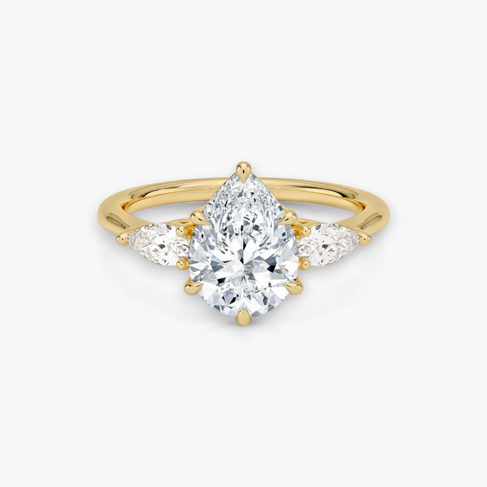 Eleganter Verlobungsring mit 2-Karat Tropfen-Cut-Diamant und funkelnden seitlichen Pear-Cut-Diamanten, gefertigt aus hochwertigem Gelbgold. Luxuriöser Diamantring für Verlobung, Hochzeit oder Jubiläum. Exklusives Schmuckdesign mit brillantem Glanz und zeitloser Eleganz – ideal für besondere Momente. Perfekter Verlobungsring mit außergewöhnlicher Handwerkskunst. Jetzt online entdecken und bestellen.