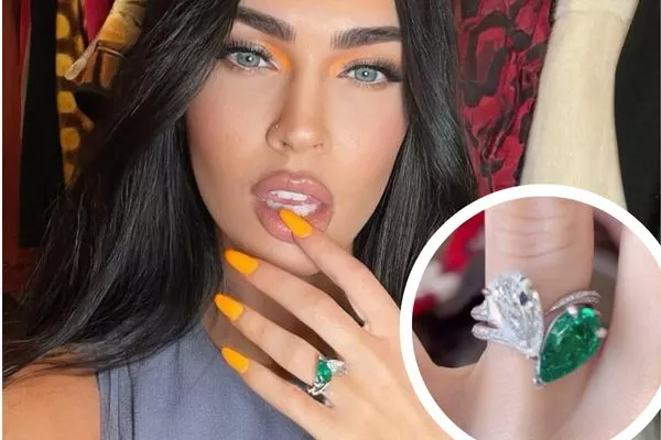 Megan Fox präsentiert ihren außergewöhnlichen Verlobungsring mit einem smaragdgrünen Edelstein und einem funkelnden Diamanten im Birnenschliff, eingefasst in ein luxuriöses Design. Diesen einzigartigen Verlobungsring können Sie bei NÓIR.com kaufen – wahlweise mit natürlichen oder labgrown Edelsteinen, garantiert zum besten Preis. Perfekt für alle, die einen unverwechselbaren und nachhaltigen Verlobungsring suchen.