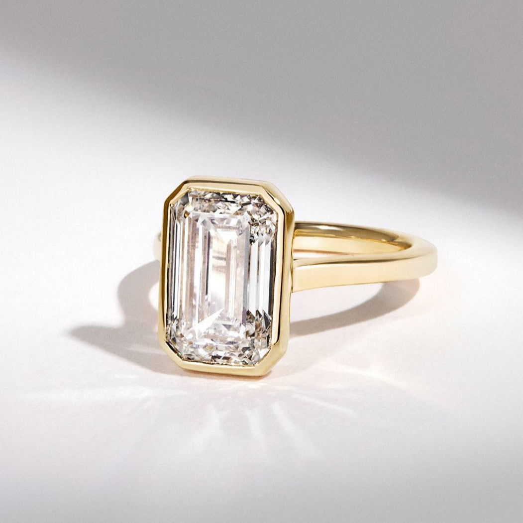 Luxuriöser Verlobungsring mit einem Emerald-Cut lab-grown Diamanten, eingefasst in einem modernen Gelbgold-Design. Perfekte Kombination aus nachhaltigen Materialien und zeitloser Eleganz, ideal für umweltbewusste Schmuckliebhaber.